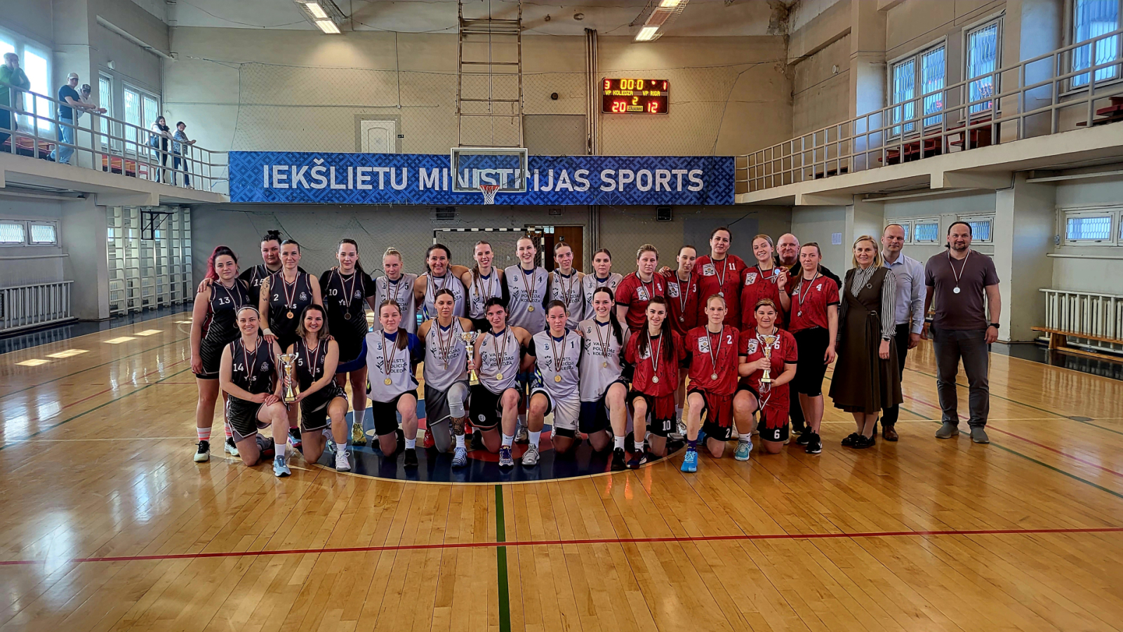 Iekšlietu ministrijas atklātā čempionāta sacensību basketbolā sievietēm uzvarētājas – trīs komandu kopbilde sporta zālē.