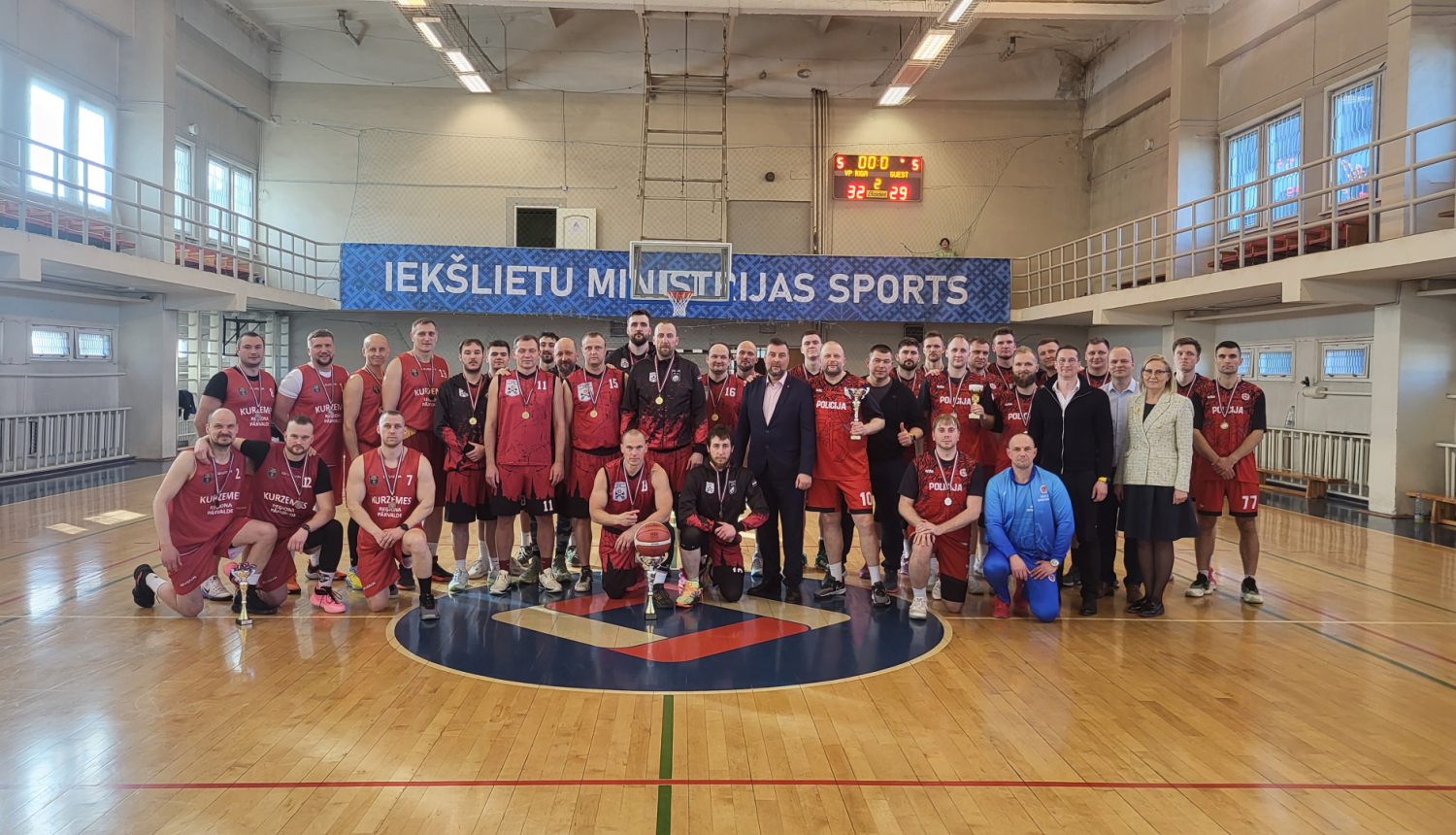 Sporta zālē visi kopā fotogrāfējas ar medeļām um kausiem
