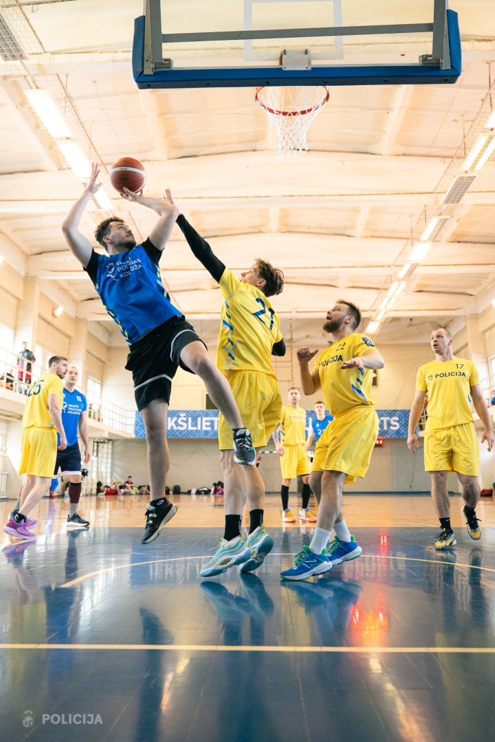 komandas spēlētāja cīņa par bumbu zem groza